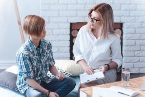 therapist and teen talking in a trauma therapy program