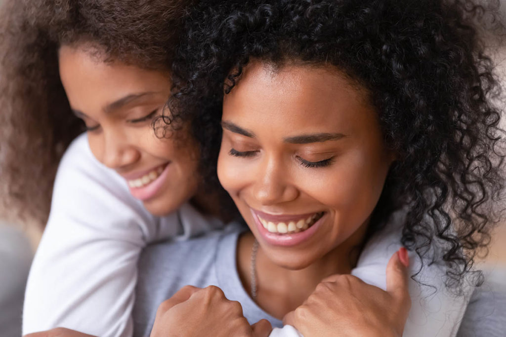 a teen hugging her mom after participating in family therapy activities for teenagers