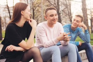 three people talking outside on a park bench about CBT techniques for bipolar disorder