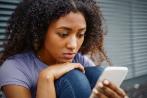 Teenager scrolling through phone while experiencing the effects of social media and depression