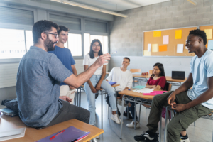 Group of happy and diverse young people in session with a counselor and exploring adolescent group therapy discussion topics