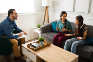 Mother and daughter in session with counselor discussing the advantages and disadvantages of family therapy