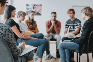 Group of diverse teenagers in session with a counselor during teen group therapy