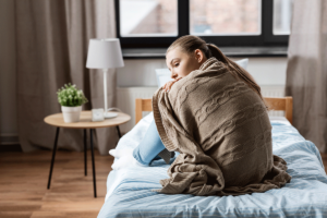 Teen sitting on bed recalling sleeping tips for teens before going to sleep
