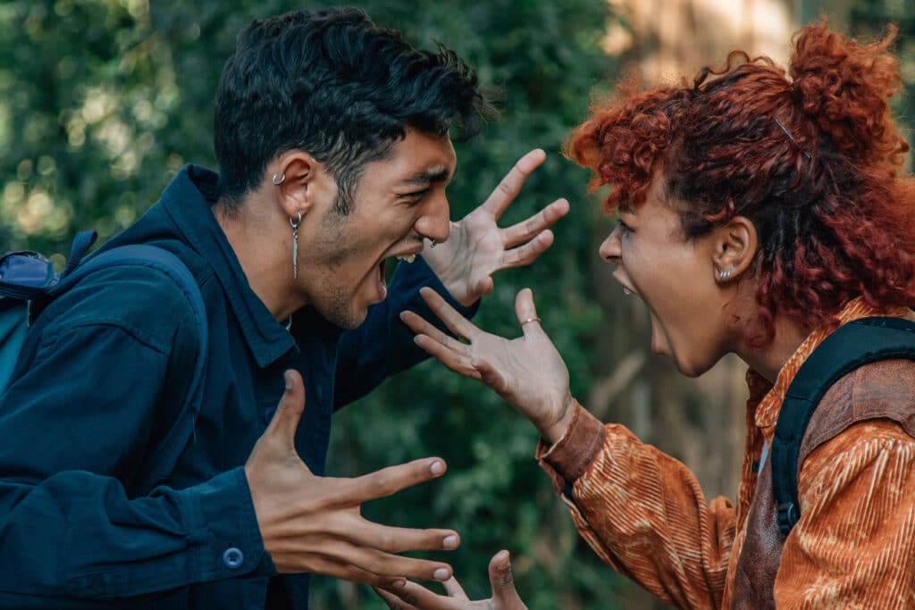 Two young people yelling at one another showing signs of anger issues