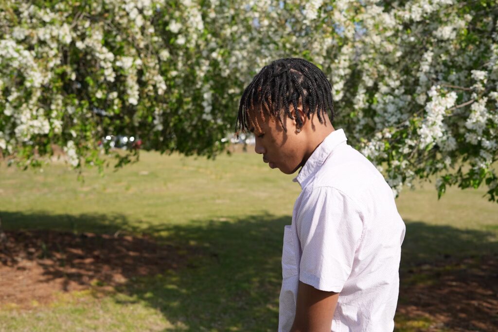 side profile of teen boy outside looking down